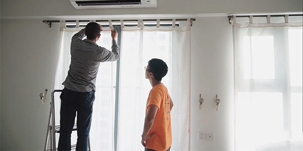 Nhân viên đang lắp rèm che nắng cửa sổ cho khách hàng