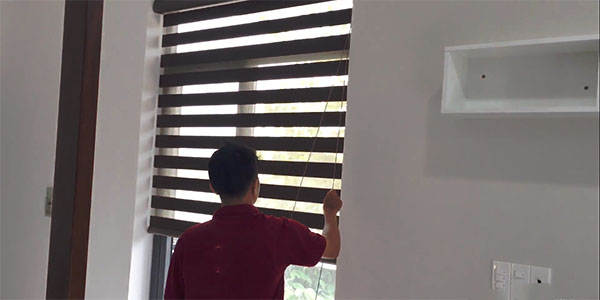 Nhân viên đang kiểm tra lại rèm cửa chống nắng sau khi lắp đặt xong 