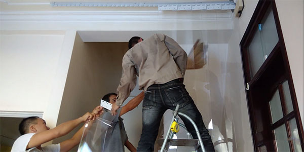 Nhân viên đang lắp đặt rèm cửa nhựa cho khách hàng