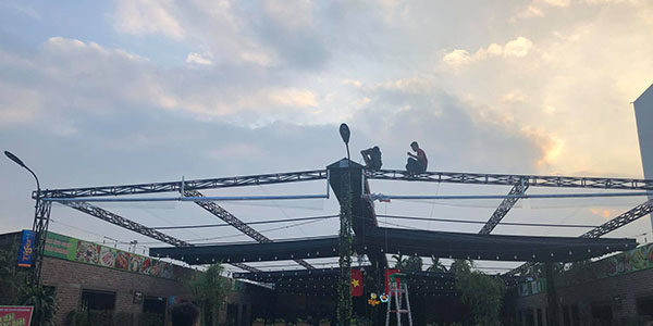 Thợ đang lắp rèm bạt ngoài trời quán cho khách hàng